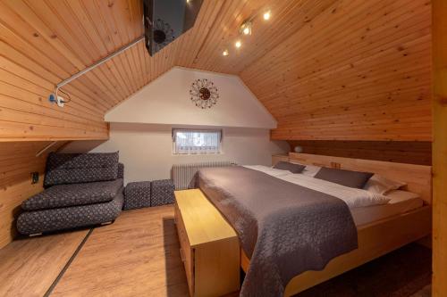 - une chambre avec un lit et une chaise dans l'établissement Apartments Kot'č, à Kranjska Gora