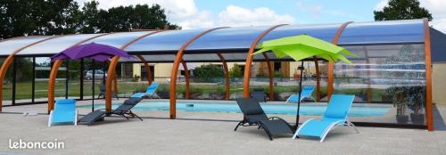 - un groupe de chaises longues et de parasols à côté de la piscine dans l'établissement Domaine Lauxley du Loc'h, à Avessac