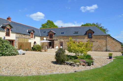 une grande maison en briques avec une cour en gravier dans l'établissement Domaine Lauxley du Loc'h, à Avessac