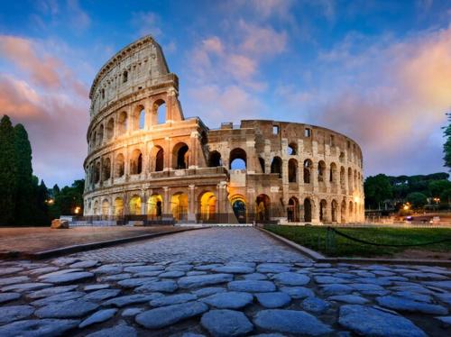 a large coliseum with a cloudy sky behind it at Mezzo Experience Holiday Home Eur in Rome