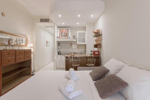 un salon avec un canapé blanc et une cuisine dans l'établissement Palais Miramar - Suite & E37 - 20M Plage - Croisette Emplacement Unique - WIFI - Clim, à Cannes