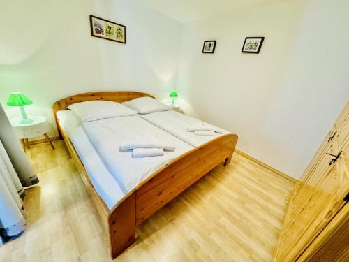 een slaapkamer met een houten bed in een kamer bij Appartement Schwalbenflug in Warnemünde