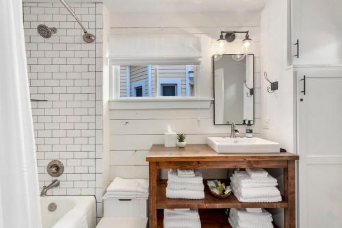 a bathroom with a sink and a mirror at The Grove Cottage - Downtown Springdale in Springdale