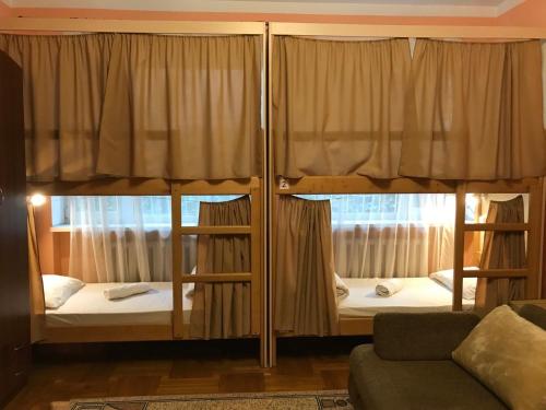 2 łóżka piętrowe w pokoju z kanapą w obiekcie Pelican Guest House & Hostel w Czerniowcach