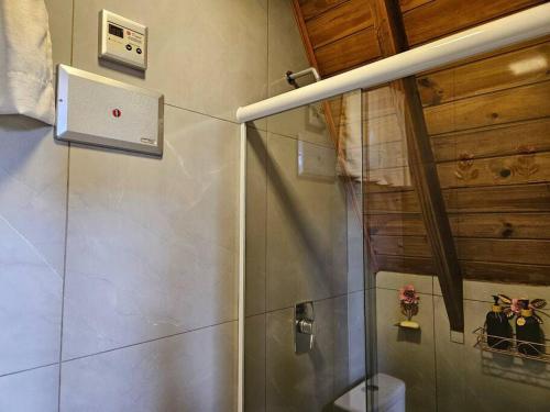 uma casa de banho com um chuveiro e uma cabina de duche em vidro. em Sítio Família Cherba - Cabana do Lago em Videira
