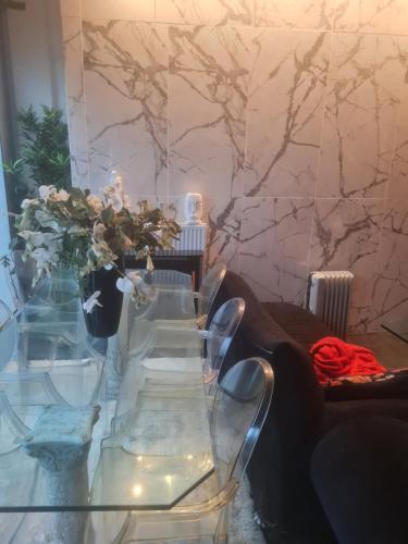 - une table en verre dans le salon avec un canapé dans l'établissement au porte des j.o, à Paris