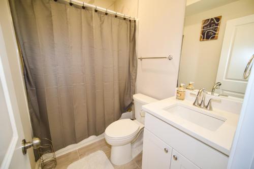 y baño con aseo, lavabo y ducha. en The Vianny:Petite Modern Lodge, en Washington