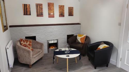 a living room with two chairs and a fireplace at 10 old church street in Cefn-coed-y-cymmer