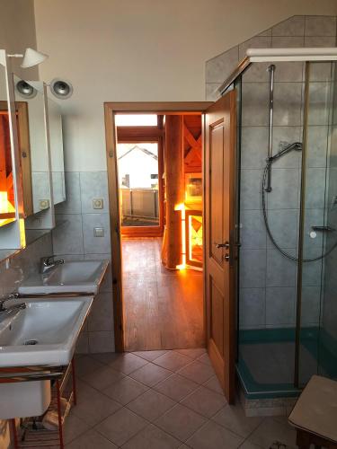 a bathroom with two sinks and a glass shower at Außergewöhnliches Ferienhaus im Schwarzwald in Dornstetten