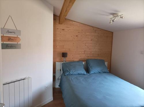 1 dormitorio con 1 cama azul en una habitación en Maison chaleureuse au calme, en Le Barp