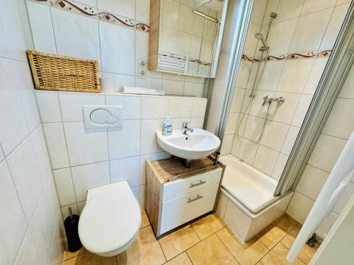 ein Bad mit einem WC, einem Waschbecken und einer Dusche in der Unterkunft Appartement Feuerdorn in Warnemünde