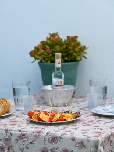 a table with a plate of food and a bottle of wine at Koskinou Traditional Houses in Koskinou