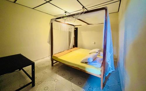 a small bed with a canopy in a room at Hostel 98 in Tissamaharama