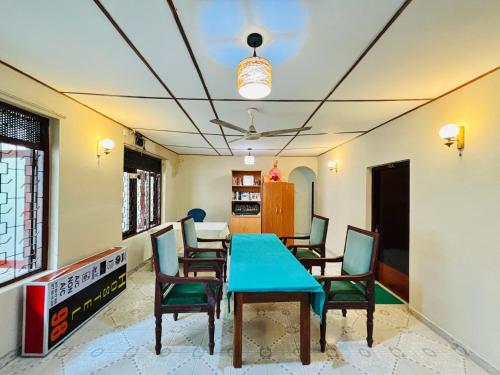 a dining room with a blue table and chairs at Hostel 98 in Tissamaharama