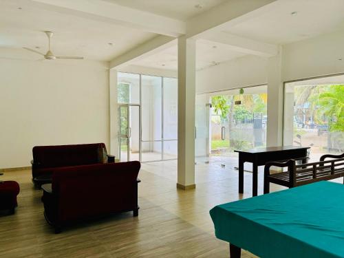 a living room with a piano and a table at Hostel 98 in Tissamaharama