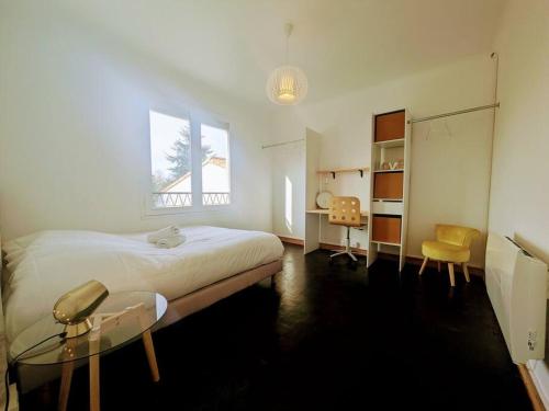 een slaapkamer met een bed, een bureau en een raam bij L'Orcerie Maison 6 pers WIFI TV parking Les Sorinières in Les Sorinières