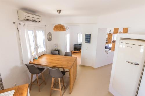 a kitchen and dining room with a wooden table and chairs at SALT SUITES MILOS in Pollonia