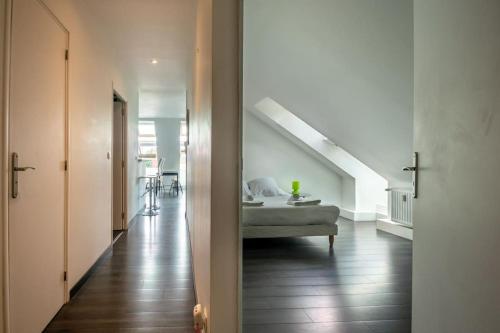 Cette chambre dispose d'un lit et d'un couloir avec un escalier. dans l'établissement Rouen, appartement sous les toits, gare + parking, à Rouen