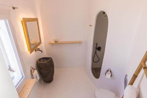 a bathroom with a large mirror and a sink at SALT SUITES MILOS in Pollonia
