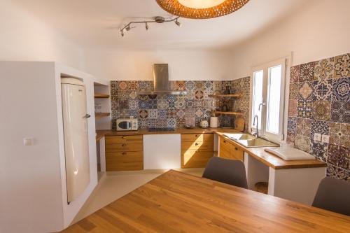 a kitchen with a table and a refrigerator and a sink at SALT SUITES MILOS in Pollonia