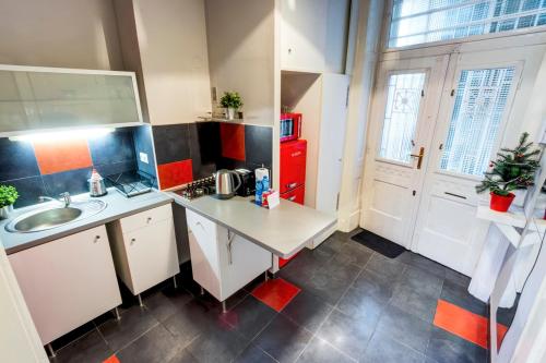 a small kitchen with a sink and a red refrigerator at S3 Sörház Apartment in Budapest