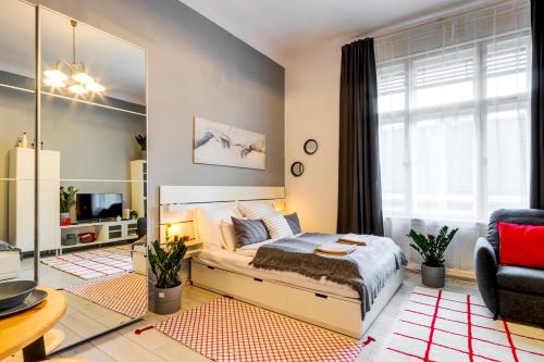 a bedroom with a bed and a living room at S3 Sörház Apartment in Budapest