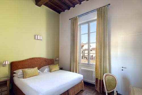 a bedroom with a bed and a large window at Residenza Della Signoria in Florence