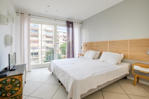 une chambre avec un lit et une grande fenêtre dans l'établissement Angelina - Belle vue mer Le003, à Cagnes-sur-Mer