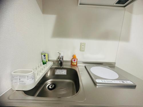 a small kitchen with a sink and a mirror at Rest collection Fushimi-Inari Kyoto in Kyoto