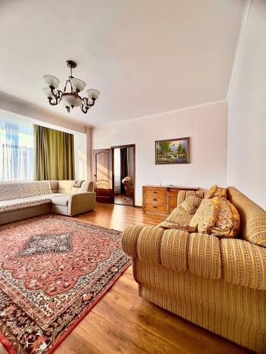 ein Wohnzimmer mit einem Sofa und einem Teppich in der Unterkunft 224 Чудесный вид на Байтерек с 2 диванами и большой кроватью для 1-5 чел in Astana