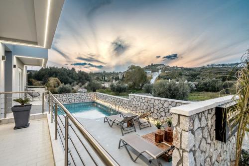 a villa with a swimming pool on a balcony at Eldorado Luxury Villa in Afantou