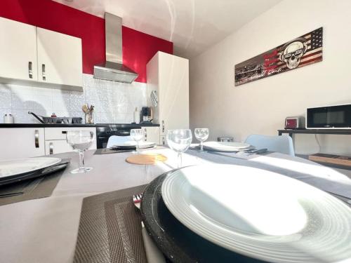 una cocina con una mesa con platos y copas de vino en Le Calypso, superbe T3+Parking proche du centre, en Poitiers