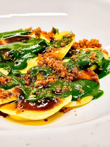 a plate of ravioli with sauce and cheese at LaChiusa Tuscany in Montefollonico