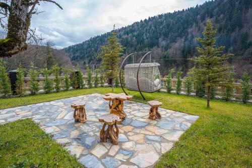 un jardín con una mesa y setas en un patio de piedra en Bİ ABANT MASALI VİLLAGE HOTEL en Markooğlu