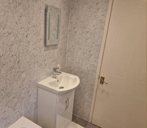een witte badkamer met een toilet en een wastafel bij Bridgend Rd. Maesteg in Garth