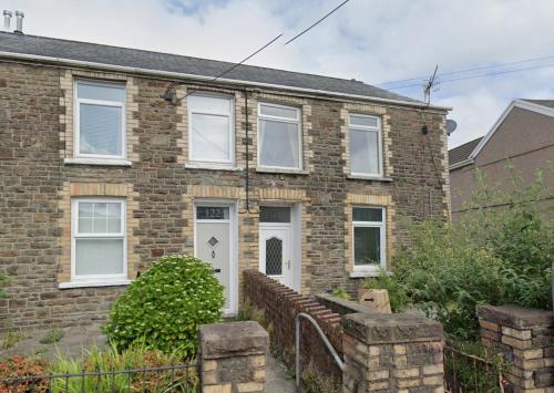 a brick house with a white door at Bridgend Rd. Maesteg in Garth