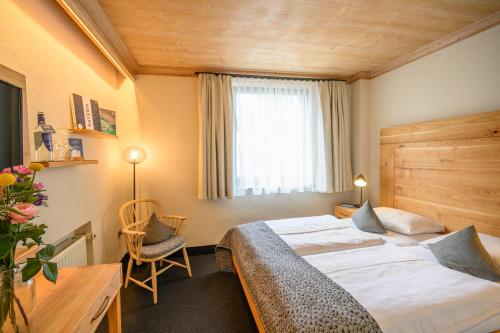 a hotel room with two beds and a window at Biohotel Garmischer Hof in Garmisch-Partenkirchen