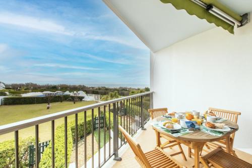 a patio with a table and chairs on a balcony at Les dunes * parking privé * piscine * Aperçue mer in La Grande-Motte