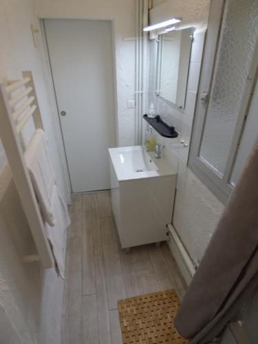 een witte badkamer met een wastafel en een spiegel bij "Le Bouquet de Pézenas" Wifi-Garage privé optionnel Centre historique-Plages à 21km ! in Pézenas