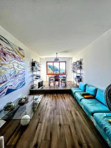 a living room with a blue couch and wooden floors at -Secret View - Marina di Carrara in Carrara
