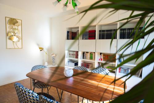 une salle à manger avec une table et des chaises en bois dans l'établissement T5 Spacieux, Parking, Proche Gare et Centre, à Dijon