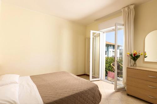 a bedroom with a bed and a sliding glass door at Residence Uno Studio&Suites in Rimini