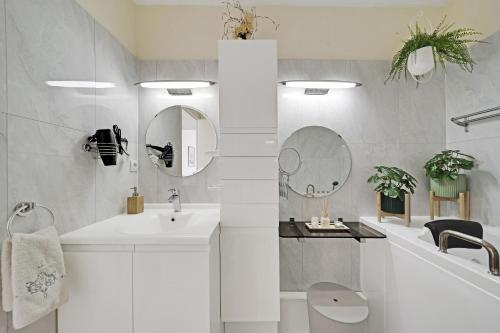 une salle de bain blanche avec un lavabo et une baignoire dans l'établissement T5 Spacieux, Parking, Proche Gare et Centre, à Dijon