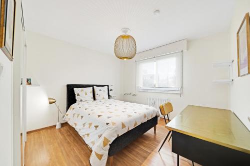 une chambre blanche avec un lit et un bureau dans l'établissement T5 Spacieux, Parking, Proche Gare et Centre, à Dijon