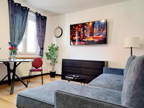 een woonkamer met een bank en een tafel bij Apartament Nova in Racibórz