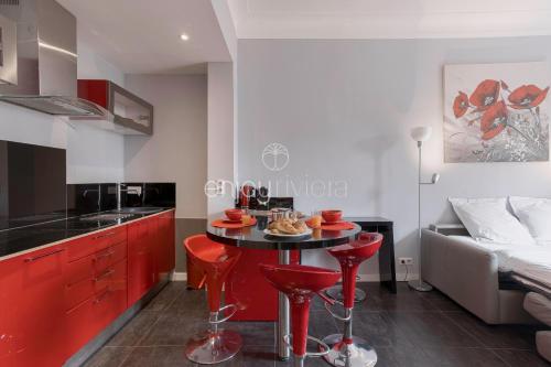 une cuisine avec des placards rouges et une table avec de la nourriture. dans l'établissement Palais Miramar - Suite & B31 - Croisette Emplacement Unique - 20M Plage - WIFI - Clim, à Cannes