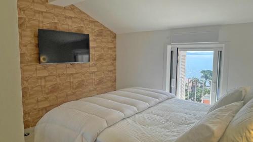 une chambre avec un lit et une télévision sur un mur dans l'établissement Grand Hotel - Appartement, à Sainte-Maxime
