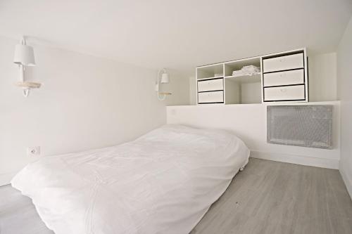 une chambre blanche avec un lit et des armoires blanches dans l'établissement Beautiful Apartment 11st District, à Paris