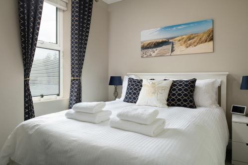 a bedroom with a white bed with towels on it at Nythfa in Llanrwst