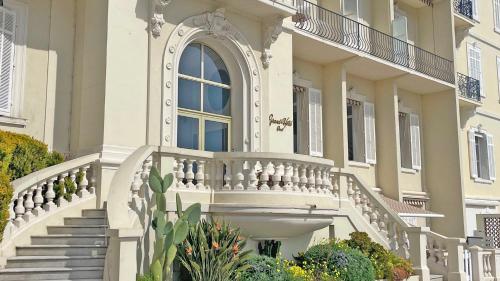 a white building with stairs and a window at Grand Hotel - Appartement in Sainte-Maxime